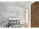 Functional Bedroom space featuring a crib and changing table with wood accents at 1705 Lewis St, Lakewood, CO 80215