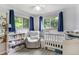 Charming Bedroom featuring a crib, chair, bookshelf, and natural light at 1705 Lewis St, Lakewood, CO 80215
