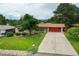Charming home with a well-manicured lawn and a long driveway leading to a red two-car garage at 1705 Lewis St, Lakewood, CO 80215