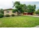 Charming brick home features a well-manicured lawn, mature trees, and a two-car garage at 1705 Lewis St, Lakewood, CO 80215
