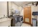Laundry room with modern washer/dryer, utility sink, and storage at 1705 Lewis St, Lakewood, CO 80215