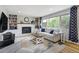 Bright living room with fireplace, built-in bookshelves, and large windows offering lots of natural light at 1705 Lewis St, Lakewood, CO 80215