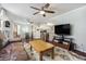 Bright living room with hardwood floors, a ceiling fan, a comfortable couch, and a TV at 1705 Lewis St, Lakewood, CO 80215