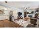 Open-concept living area with hardwood floors, a ceiling fan, a comfortable couch, and a fireplace at 1705 Lewis St, Lakewood, CO 80215