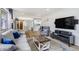 Open-concept living room with hardwood floors offering views into the kitchen and dining area at 1705 Lewis St, Lakewood, CO 80215