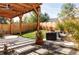 Cozy backyard patio area with comfortable seating, fire pit, lush grass, and a stylish pergola overhead at 108 Arapahoe St, Golden, CO 80403