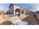 Large backyard with a covered patio, grill, fenced-in yard and a mix of snow and dry grass at 10031 Truckee St, Commerce City, CO 80022