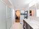 Modern bathroom featuring a glass-enclosed shower, double vanity with white countertops, and walk-in closet access at 10031 Truckee St, Commerce City, CO 80022