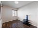 Bedroom with wood-look floors, window with blinds, and a corner shelving unit at 10031 Truckee St, Commerce City, CO 80022