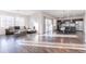 Open-concept living area with hardwood floors, a modern sofa, large windows, and a view of the kitchen at 10031 Truckee St, Commerce City, CO 80022
