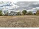 Expansive backyard with a view of the home, mature trees, and open space at 18715 Wagon Trl, Mead, CO 80542