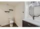 Powder room featuring dark vanity with white sink, a modern light fixture, and wall shelves at 18715 Wagon Trl, Mead, CO 80542