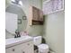 Powder room with a single vanity, cabinet, and unique mirror at 18715 Wagon Trl, Mead, CO 80542