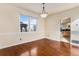 Dining area featuring hardwood flooring, a modern chandelier, and a large window at 18715 Wagon Trl, Mead, CO 80542