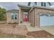 Close-up of the front entrance featuring a red door with decorative glass and brick accents at 18715 Wagon Trl, Mead, CO 80542