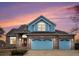 Charming two-story home with brick accents, blue siding, and a three-car garage at 18715 Wagon Trl, Mead, CO 80542