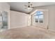 Bright primary bedroom with vaulted ceilings, ceiling fan, and large arched window at 18715 Wagon Trl, Mead, CO 80542