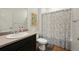 Well-lit bathroom featuring a vanity with sink and a shower with decorative shower curtain at 6912 Poudre St, Frederick, CO 80530