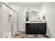 Well-lit bathroom featuring a double sink vanity and a glass-enclosed shower at 6912 Poudre St, Frederick, CO 80530