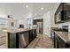 Modern kitchen with island open to the living room with stainless appliances and dark cabinetry at 6912 Poudre St, Frederick, CO 80530