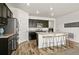 Modern kitchen featuring dark cabinets, stainless steel appliances, and an island with bar seating at 6912 Poudre St, Frederick, CO 80530