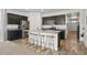 Modern kitchen featuring dark cabinets, stainless steel appliances, and an island with bar seating at 6912 Poudre St, Frederick, CO 80530