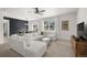 Open living area featuring neutral tones, a plush sectional, and ample natural light at 6912 Poudre St, Frederick, CO 80530