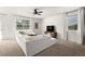 Bright living room with plush white seating, large windows, and a ceiling fan at 6912 Poudre St, Frederick, CO 80530
