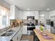 Modern kitchen with white cabinets, stainless steel appliances, granite countertops, and a breakfast bar island for casual dining at 1385 S Newton St, Denver, CO 80219