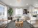 Bright living room showcasing modern furniture, hardwood floors, a stylish rug, and a seamless transition into the kitchen area at 1385 S Newton St, Denver, CO 80219