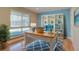 Well-lit office with a desk, chair, bookshelf, a large window and a blue accent wall at 6495 E Happy Canyon Rd # 22, Denver, CO 80237