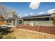 Back exterior of house with solar panels and brick perimeter, featuring a well-kept lawn at 863 S Dudley St, Lakewood, CO 80226