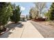 Long driveway leads to a charming home exterior with mature trees and landscaping at 863 S Dudley St, Lakewood, CO 80226
