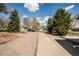 Long driveway leading to the home, with mature trees, gravel, and a parking area at 863 S Dudley St, Lakewood, CO 80226