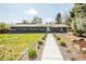 Charming one-story home with green brick, manicured lawn, and walkway to the entrance at 863 S Dudley St, Lakewood, CO 80226