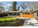 View of the detached garage, featuring a well-manicured lawn and adjacent driveway at 863 S Dudley St, Lakewood, CO 80226