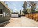 Wide view of the two-car detached garage, concrete driveway and fenced yard at 863 S Dudley St, Lakewood, CO 80226