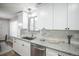 Updated kitchen features white cabinets, granite countertops, and stainless steel appliances at 863 S Dudley St, Lakewood, CO 80226