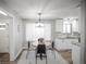 Bright dining area with new lighting next to a kitchen with white cabinetry and granite countertops at 863 S Dudley St, Lakewood, CO 80226