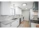 Updated kitchen with white cabinets, granite countertops, stainless steel appliances, and wooden floors at 863 S Dudley St, Lakewood, CO 80226