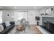 Bright living room with fireplace, grey walls, wooden floors, and black sofa at 863 S Dudley St, Lakewood, CO 80226