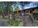 Backyard deck with railings, patio furniture, landscaped yard, and mature trees at 207 County Road 65, Evergreen, CO 80439