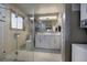 Modern bathroom with a double sink vanity, glass enclosed shower, and integrated laundry at 207 County Road 65, Evergreen, CO 80439