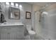 Bright bathroom with a glass-enclosed shower, white vanity and a decorative mirror at 207 County Road 65, Evergreen, CO 80439