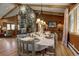 Inviting dining room with a stone fireplace, wooden table set for six, and warm ambiance at 207 County Road 65, Evergreen, CO 80439