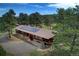 An aerial view of the home featuring a long roof with solar panels, mature trees, and a driveway at 207 County Road 65, Evergreen, CO 80439