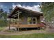 Exterior view of home with wood siding, deck, railings, patio furniture, and surrounding landscaping at 207 County Road 65, Evergreen, CO 80439