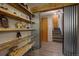 Hallway with custom shelving, wood-look floors, metal sliding partition, and stairs to the second floor at 207 County Road 65, Evergreen, CO 80439