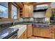 Bright kitchen featuring custom wood cabinets, granite countertops, stainless steel appliances and farm style sink at 207 County Road 65, Evergreen, CO 80439