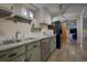 Kitchenette featuring marble countertops, wood-look floors, stainless steel sink, and sliding barn door to living room at 207 County Road 65, Evergreen, CO 80439
